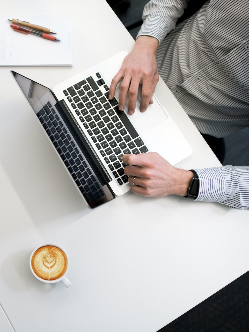 person using laptop on white wooden table